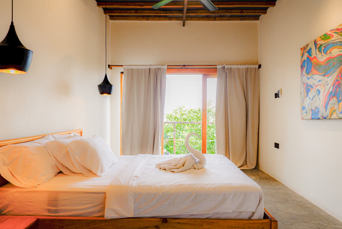 The Langkawi bed facing a window full of green